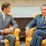 A diverse group in formal attire discussing King Charles visits US.