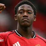 Young football professionals discussing strategy in a modern office setting.