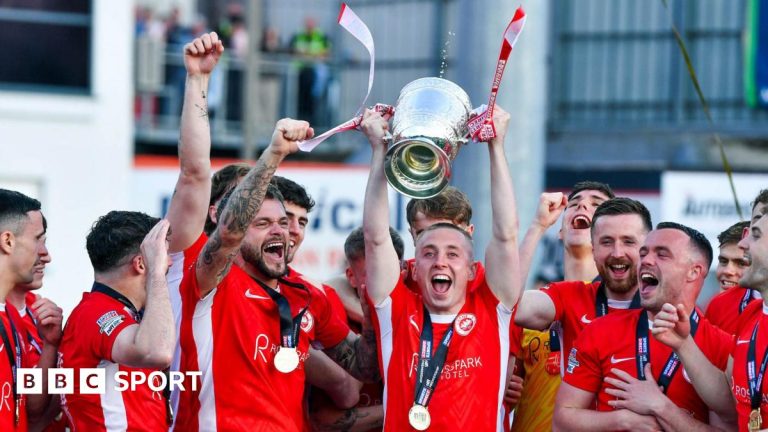 Larne FC celebrating their Irish Premiership victory with fans cheering.