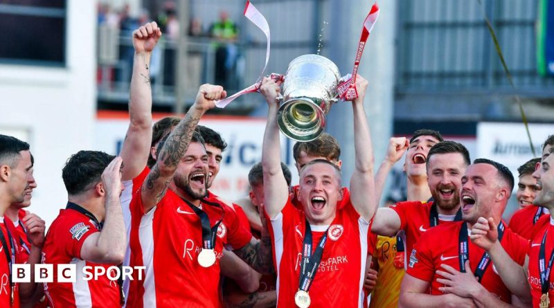 Larne FC celebrating their Irish Premiership victory with fans cheering.