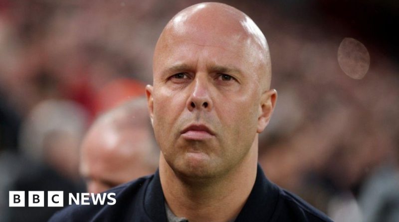 A group of individuals in professional attire holding candles at a memorial for the Hillsborough Law delay.