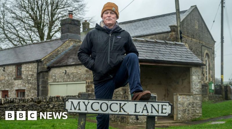 A diverse group of professionals enjoying humor about unique surnames in an office.