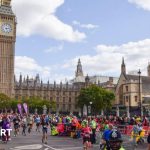 A group of people participating in a London Marathon quiz event, focused and engaged.