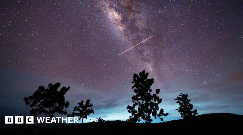 People in professional attire watching the Lyrid meteor shower in a clear night sky.