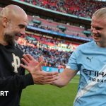 Manchester City treble quest celebrated by players on field.