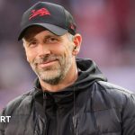 A group of coaches discussing strategies for the Bournemouth manager transition.