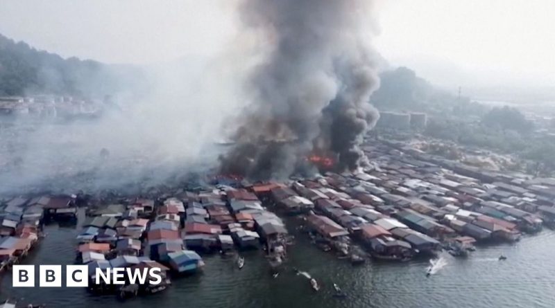 Emergency responders assist families affected by the Malaysian village fire.