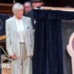 Community members gather around a memorial for PC Andrew Harper, honoring his bravery.
