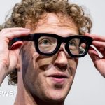 Professionals discussing Meta job cuts in a modern office setting.