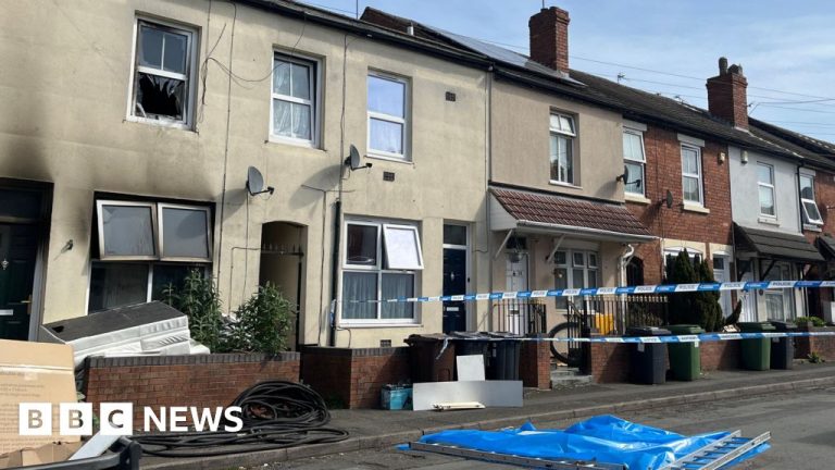 Community members gather near the scene of the house fire in Wolverhampton.