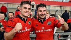 Munster vs Ulster rugby match showing players in action and a cheering crowd.