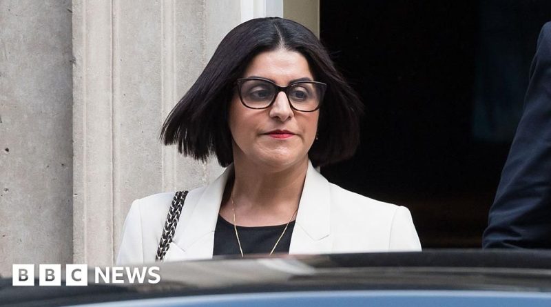 Professionals in business attire discussing asylum policies in an office setting.