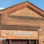 A busy creative hub in Hull with artists using green screens and cameras.