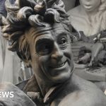 A crowd admires the Terry Jones statue during its unveiling ceremony, celebrating his comedic legacy.