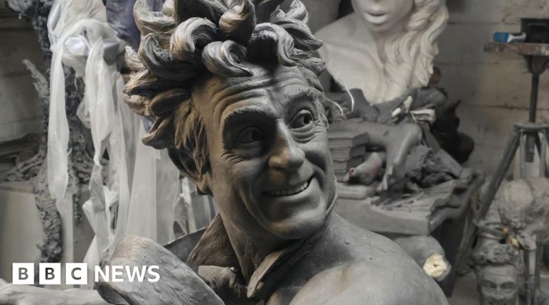 A crowd admires the Terry Jones statue during its unveiling ceremony, celebrating his comedic legacy.