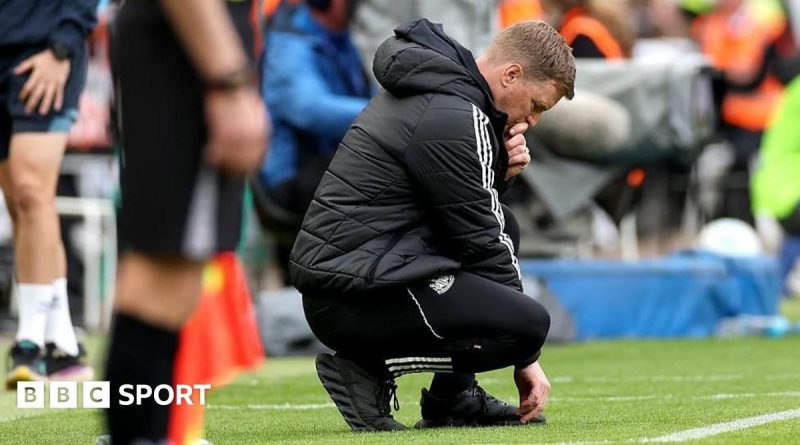 Eddie Howe Newcastle United discussing strategies with soccer coaches on the field.