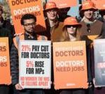 Healthcare professionals in a busy NHS hospital managing patient care during the doctors' strike.