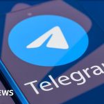 Professionals discussing the Telegram child safety investigation in an office.