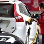 Professionals discussing oil prices rise in a modern office setting.