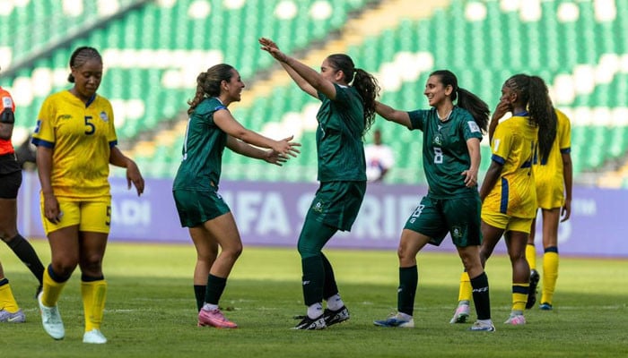 Pakistan women's football team celebrating a goal during a historic match.