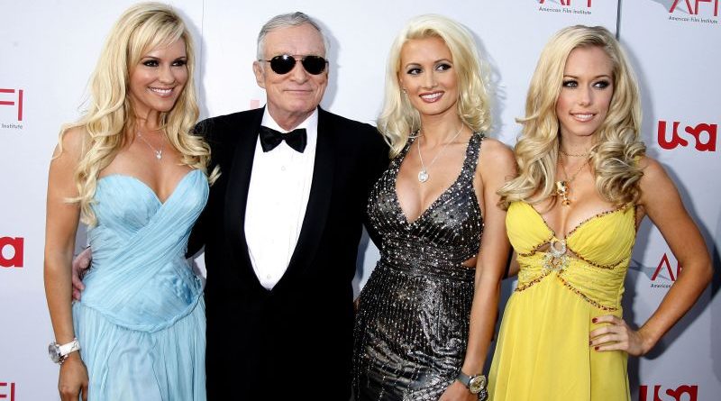 A diverse group discussing Playboy rebranding strategies in a professional setting.