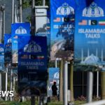 Professionals in conservative attire discussing plans for Islamabad peace talks.