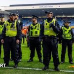 Fans passionately supporting their teams during the Rangers Celtic derby.