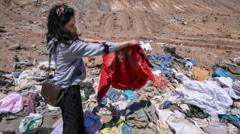Piles of discarded clothing in a desert highlighting recycled clothes disposal.