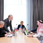 Politicians discussing Trump Iran conflict strategy in a conference room.