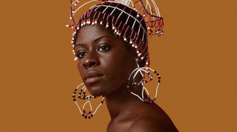 A diverse group in professional attire admiring Kwame Brathwaite photography in an art gallery.