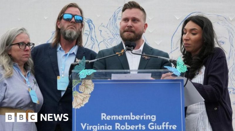 Virginia Giuffre vigil with attendees holding candles and signs in remembrance.
