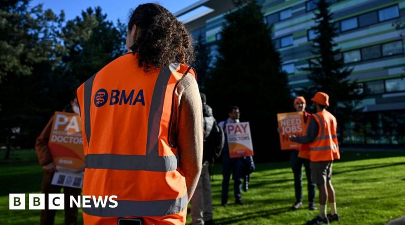 Resident doctors in England discussing their pay dispute in a hospital.