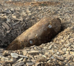 WWII bomb disposal scene with experts and evacuated homes nearby.