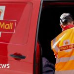 Postal workers collaborating to meet Royal Mail delivery targets in a sorting facility.