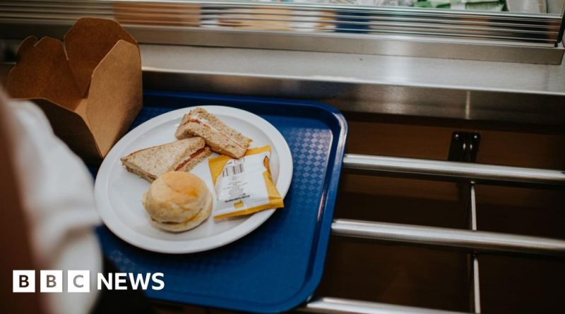 Teachers preparing a free breakfast program in a school cafeteria.