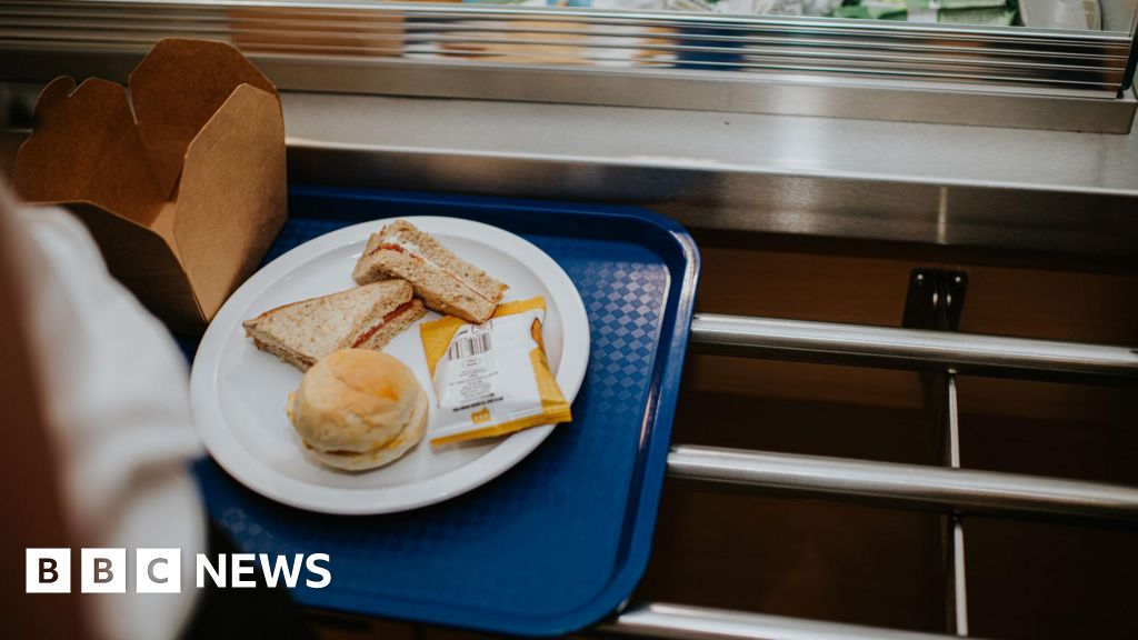 Teachers preparing a free breakfast program in a school cafeteria.