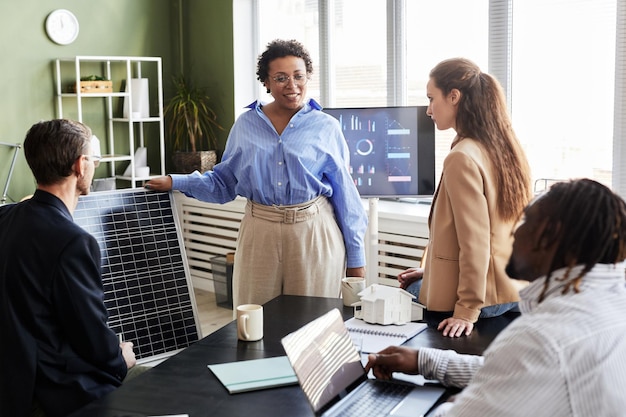 Professionals discussing heat pump installation and climate action in a modern office.