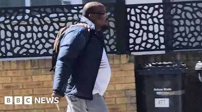 Police discussing the Golders Green stabbing suspect case in a busy urban area.