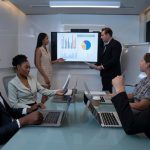 A group of professionals discussing economic challenges during a Starmer conference.