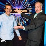 A joyful celebration of a Millionaire jackpot winner with diverse people in formal attire.