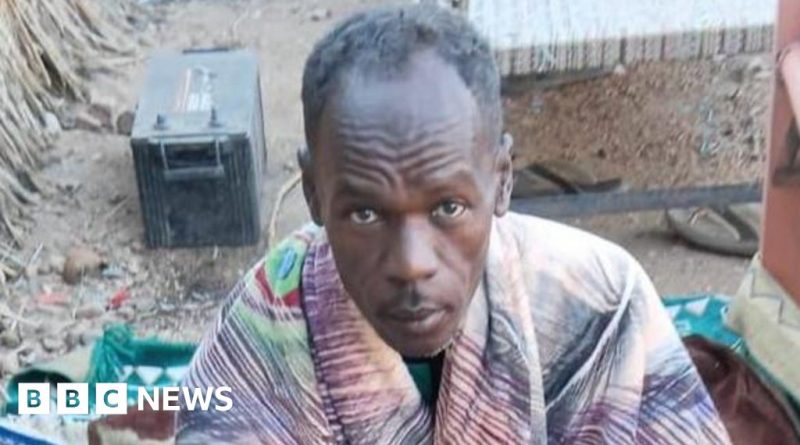 A Sudan conflict journalist reading important messages on his phone.