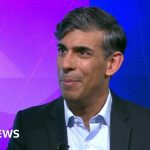 Group of professionals discussing job tax removal for AI competition in a modern office.