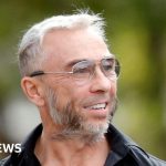 A courtroom scene depicting professionals discussing the Superdry co-founder trial.