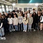 A group of children discussing social media restrictions in a classroom setting.