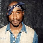 A serious meeting about the Tupac wrongful death lawsuit in an office.