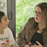 A diverse group of UK families discussing financial struggles and budgeting together.