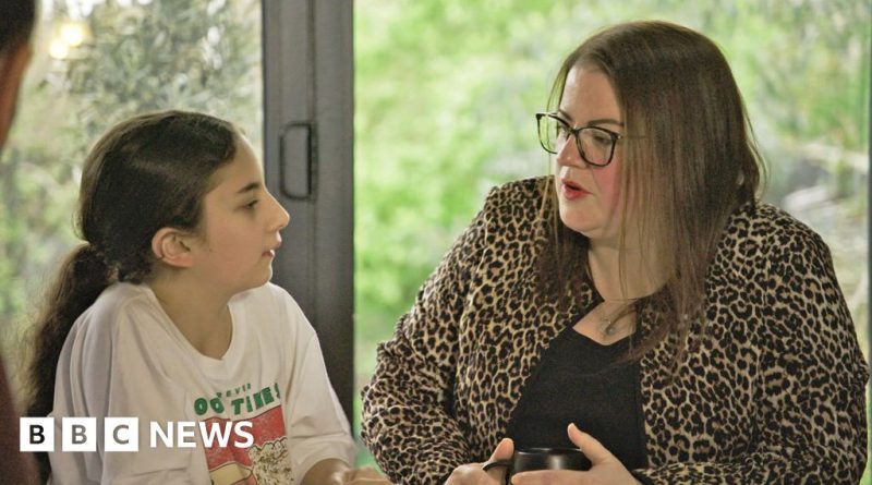 A diverse group of UK families discussing financial struggles and budgeting together.