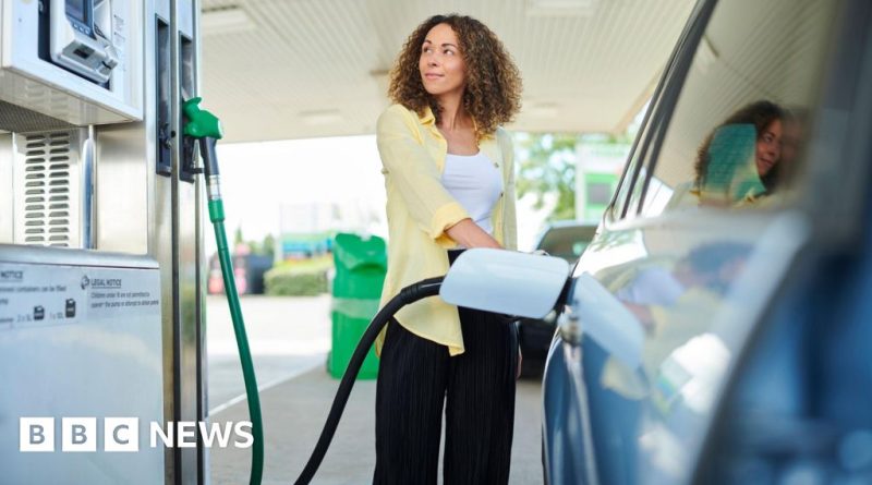 Group of professionals discussing UK fuel prices at a station.