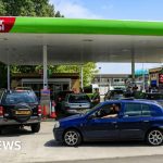 Group of professionals discussing UK inflation increase in a formal setting.