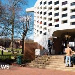 Students engaged in a discussion about free speech policies in a classroom setting.